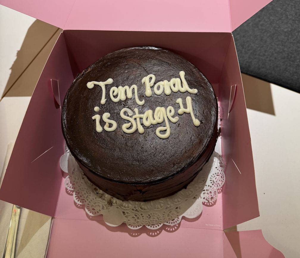 A chocolate cake celebrating Temporal reaching Stage 4, with the writing "Temporal is Stage 4" in white icing on the top